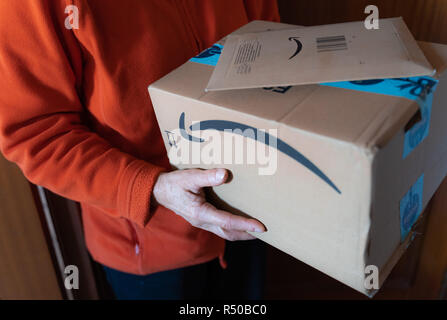 Valencia, Spanien - November 28, 2018: Frauen, die Amazon Prime Package. Geliefert amazon Box nach dem schwarzen Freitag und Cyber Monday Rabatte. Kleine bin Stockfoto