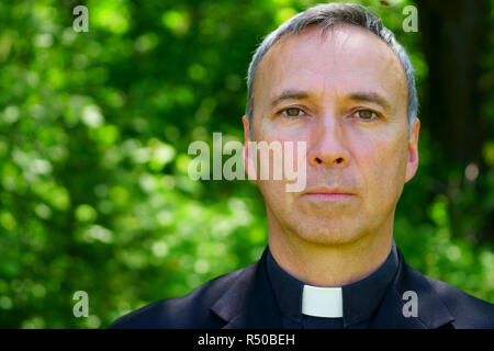 Ein katholischer Priester in den Wald steht, bei uns suchen, konzentrieren. Stockfoto