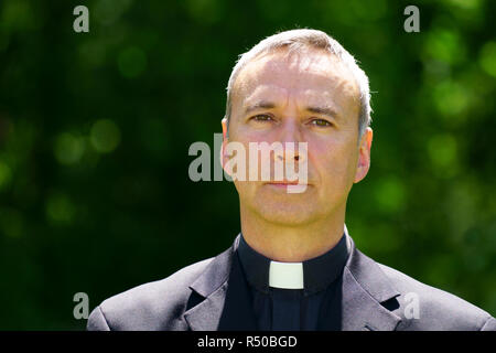 Ein katholischer Priester im Garten steht, bei uns ernsthaft suchen. Stockfoto