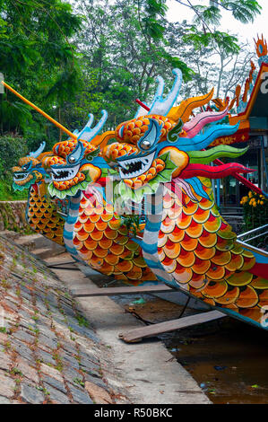 Drachen Boote aufgereiht und warten auf Touristen außerhalb der Thien Mu Pagode auf den Perfume River und Hue, Vietnam Stockfoto