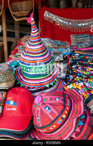 Eine Auswahl an bunten lokalen Merchandise, Hüte, Schals, Taschen, und Souvenirs zum Verkauf auf Marktstand - Luang Prabang, Laos, Lao Stockfoto