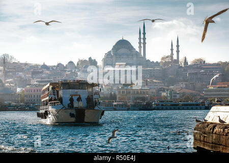 Eine Fähre mit Passagieren auf Haliç, das Goldene Horn mit Suleymaniye Moschee im Hintergrund, Istanbul, Türkei Stockfoto