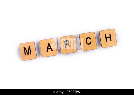 März, Dinkel mit hölzernen Buchstabensteine über einen weißen Hintergrund. Stockfoto