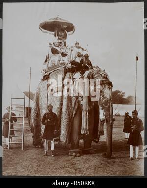 Ihre Exzellenzen Lord und Lady Curzon über den Elefanten "Lutchmann Pershad' [Delhi Durbar]. Die silberne howdah ist das Gleiche, in dem Seine Majestät der King-Emperor fuhr bei seinem Besuch in Indien 1875. Die caparisoned Zustand Elefant trägt die Silber howdah. Die Zahlen der Lord und Lady Curzon haben auf das Bild montaged gewesen. Teilnehmer gruppiert rund um die Elefanten und einem Betrieb einen Schirm über das Paar. Curzon Sammlung: "Krönung Durbar, Delhi, 1903. Seiner Majestät König Edward VII. Vizekönig. Baron Curzon von Kedleston, S. C., G.M.S.I., G.M.I.E.". 29. Dez. 1902. Foto. Quelle: Stockfoto
