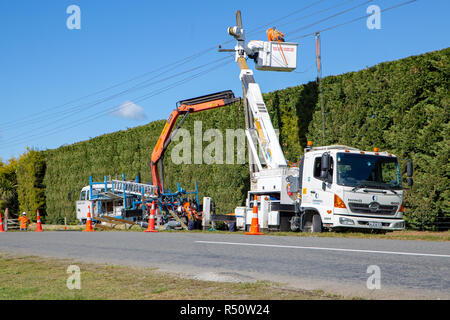Coalgate, Canterbury, Neuseeland - 27. September 2018: Power Linienrichter arbeiten auf dem Setzen neue Pole und Instandsetzung und Verbesserung der Stromversorgung Stockfoto