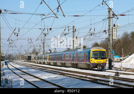 Ein paar der Klasse 365 elektrische Triebzüge aus einem Verschneiten Hitchin Station auf der East Coast Mainline abfliegen. Stockfoto