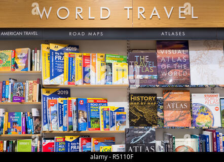 Cambridge, England - Oktober 2018: die Innere eines modernen Waterstones Buchhandlung, World Travel Abschnitt, mit hölzernen Regale voller Bücher. Stockfoto