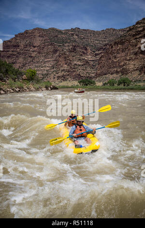 Ein Mann und eine Frau das Paddeln eine aufblasbare Kajak durch Stromschnellen auf einem Green River Rafting Trip Wüst/Grau Canyon, Utah, USA Stockfoto