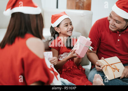 Glückliche Tochter lachend, nachdem sie von ihrer Mutter während Weihnachten Stockfoto
