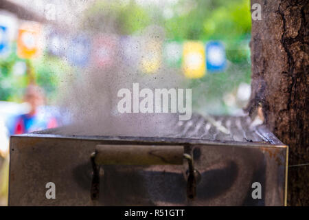 Highspeed Foto des Wassers platzen heraus aus dem Ballon, die auf einem heißen Grill platziert Stockfoto