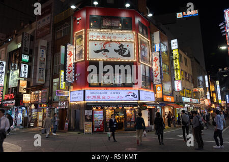 Hauptstraße in Shinjuku, Tokyo, Japan bei Nacht mit Fußgängern zu Fuß durch Stockfoto