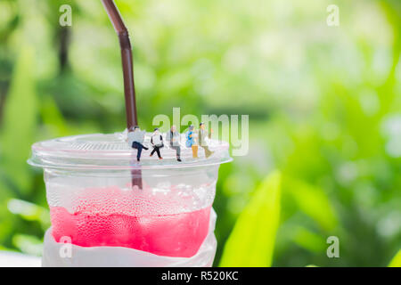 Miniatur Geschäftsmann und Business Mädchen lesen ein Buch oder eine Zeitung und das Sitzen auf dem Plastik Tasse trinken, die Sie als Business und Bildung. Stockfoto