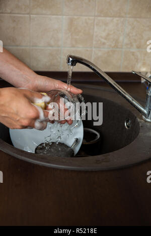 Bild von Seite der Hände des Menschen waschen Transparente Becher in Waschbecken Stockfoto