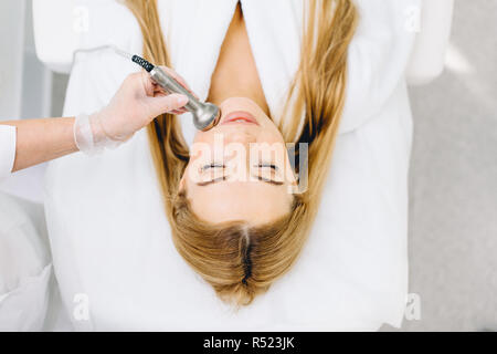 Blonde Frau hat Ultraschall dinamic lift Massage im Spa, hardware Apparat. Stockfoto