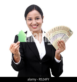 Young Business Frau mit Haus Modell und Indische Rupie Notizen Stockfoto