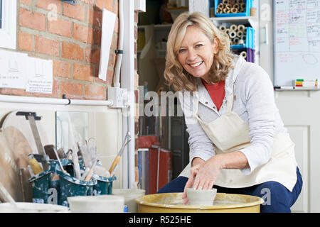 Porträt von Reife Frau, die Arbeiten an der Töpferscheibe In Studio Stockfoto