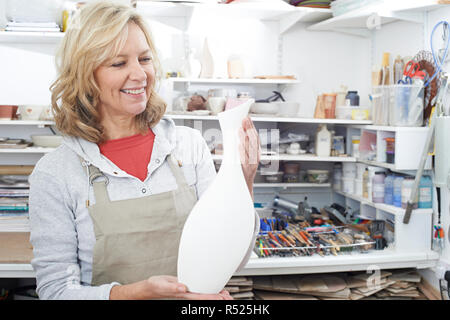 Reife Frau mit Vase aus Keramik Studio Stockfoto