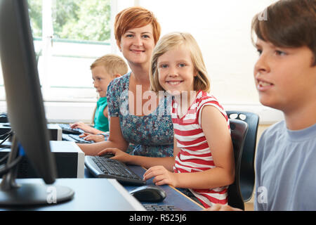 Portrait der weiblichen Schüler in der Grundschule Computer Klasse mit Lehrer Stockfoto