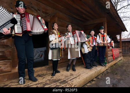 Uschhorod, Ukraine - Jan 13, 2018: Vasylya Festival im Museum der Volksarchitektur und Leben. Gruppe von Kindern in den traditionellen Farben singen Hütte Stockfoto