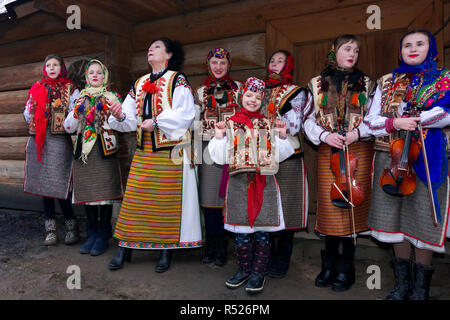 Uschhorod, Ukraine - Jan 13, 2018: Vasylya Festival im Museum der Volksarchitektur und Leben. Gruppe von Kindern in den traditionellen Farben singen Hütte Stockfoto