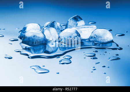 Schmelzende Eiswürfel auf eine homogene Hintergrund in blau getönt Stockfoto