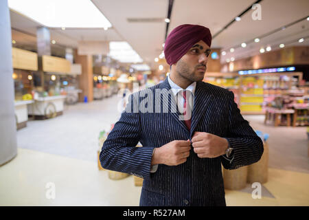 Portrait von indischer Geschäftsmann mit Turban in der Shopping Mall Stockfoto