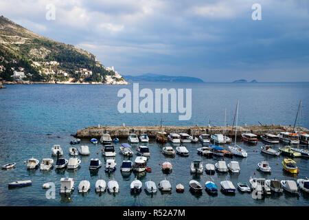 Die Boote im Hafen von Dubrovnik mit Berg- und dramatische cloudscape gesäumt, Kroatien Stockfoto