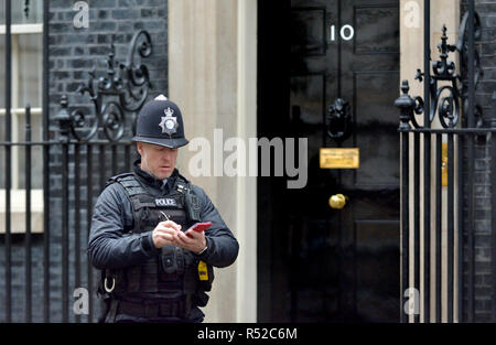 Polizisten schreiben in seinem Notebook außerhalb 10 Downing Street, London, England, UK. Stockfoto