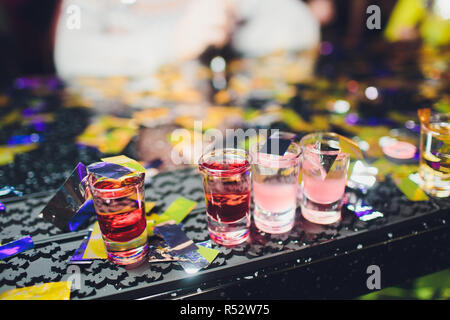 Variation der harten alkoholischen Schüsse auf Theke serviert. Blur Flaschen für den Hintergrund. Stockfoto