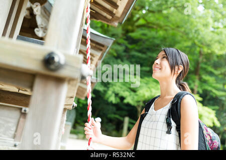 Frau Läuten der Glocke in japanischen Tempel Stockfoto