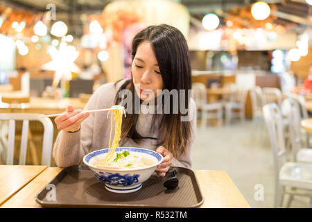 Junge Frau ramen Essen im Restaurant Stockfoto