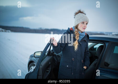 Frau Auto fahren - weibliche Fahrer an einem Rad eines modernen Autos, glücklich lächelnd mit einem entspannten Lächeln (flacher DOF Farbe getonte Bild) Stockfoto