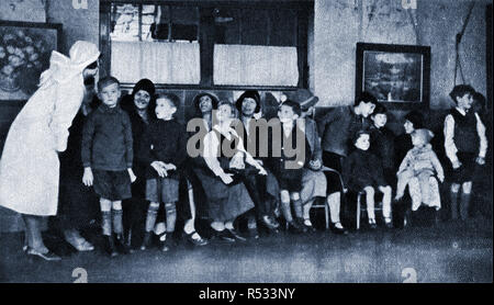 1934 - Schule Kinder in Großbritannien warten eine der neuen Schule zahnmedizinische Kliniken zu sorgen. Eine Krankenschwester Chats auf die Mütter und Kinder. Stockfoto