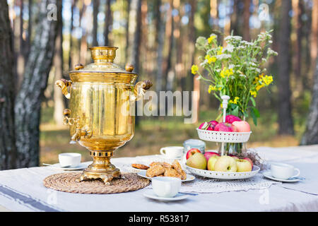 Nahaufnahme eines traditionellen russischen Samowar mit Cups auf eine Tabelle mit Snacks Stockfoto