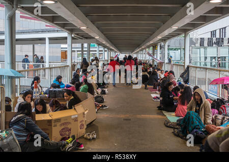 Weibliche Arbeitnehmer aus Indonesien und den Philippinen Treffen am Sonntag auf einem Gehweg in der Admiralität. Hong Kong, Januar 2018 Stockfoto