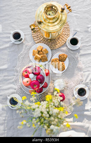 Blick von oben auf Tabelle mit Samowar, Kaffeetassen, Süßigkeiten Stockfoto