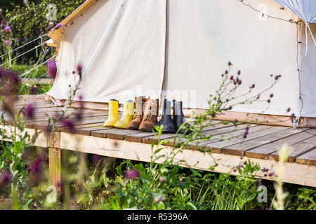 Nahaufnahme einer Leinwand bell Zelt mit Schuhen auf einem Holzsockel Stockfoto