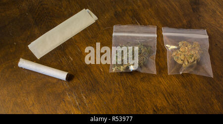 Zwei Beutel mit Cannabis und eine Zigarette und Rolling Paper. Stockfoto