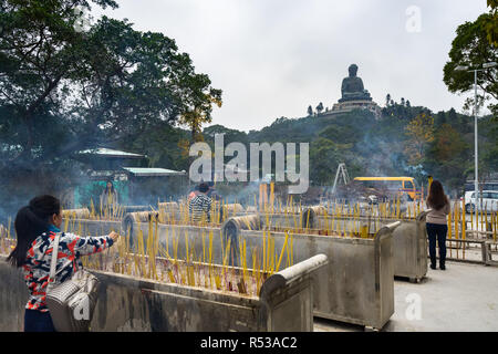 Besucher beten und bieten Weihrauch zum Tian Tan Buddha. Hong Kong, Ngong Ping, Lantau Island, Januar 2018 Stockfoto