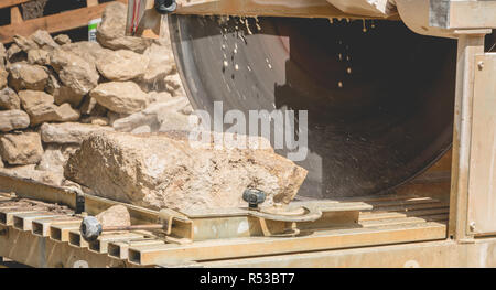 Man schneiden einen Stein mit einem Wasser sah Stockfoto