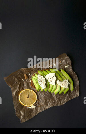 Frische und köstliche avocado Toast mit Käse auf schwarzen Hintergrund mit Copyspace. Stockfoto