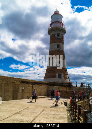 Leute, die in der Nähe des Leuchtturms am Ende des Roker Pier, Sunderland, England, Großbritannien fischen Stockfoto