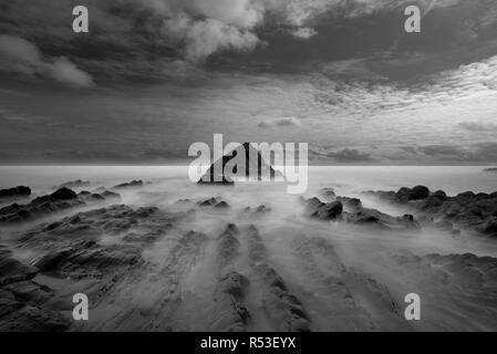 Verschlusszeit von Abendlicht und Flut über die jugged Sandstein Felsformationen auf Sandymouth Strand an der Nordküste von Cornwall Stockfoto