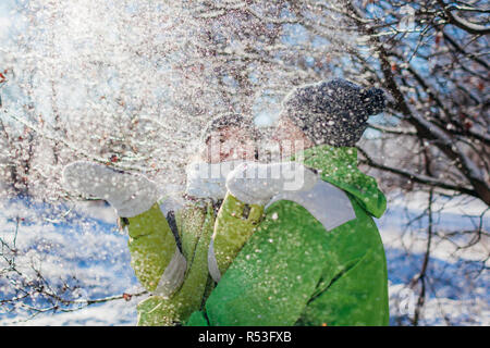 Verliebtes Paar werfen Schnee und Umarmen im Winter Wald. Junge Leute Spaß haben während der Ferien Stockfoto