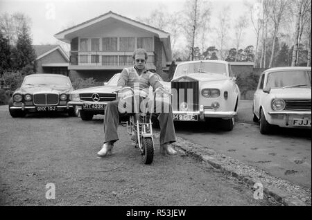 Elton John dargestellt an seinem Haus, auf einem kleinen Motorrad vor vier seiner Autos. Seine Autos gehören ein Mercedes (2. links) und einem weißen Rolls Royce (3. links) Bild 4 April 1972 Stockfoto