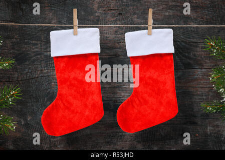 Weihnachten rote Socken am Seil. Holz- Hintergrund. Stockfoto