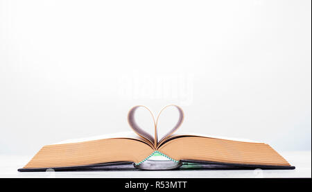 Valentinstag oder lesen Konzept mit herzförmigen Buch auf weißem Hintergrund Stockfoto