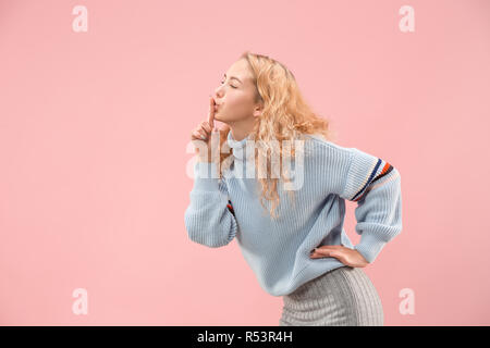 Geheimnis, Klatsch-Konzept. Junge Frau flüstert ein Geheimnis hinter ihrer Hand. Business woman am trendigen Pink Studio Hintergrund isoliert. Junge emotionale Frau. Menschliche Gefühle, Mimik Konzept. Stockfoto