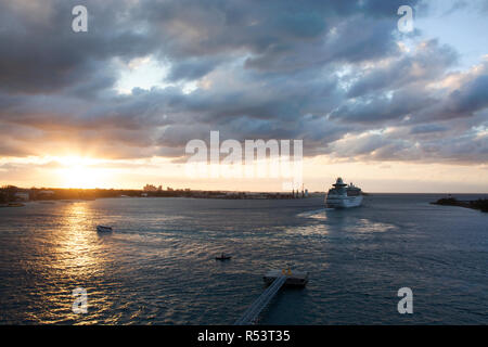 Die Aussicht auf ein Kreuzfahrtschiff verlässt den Hafen von Nassau in den Sonnenuntergang (Bahamas). Stockfoto