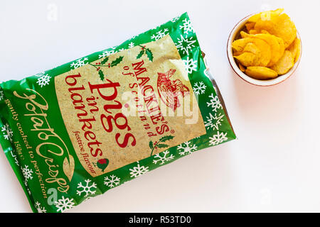 Öffnen Paket von Mackie's von Schottland Schweine in Decken festlichen Geschmack Kartoffelchips mit Chips in der Schüssel auf weißem Hintergrund - bereit für Weihnachten Stockfoto